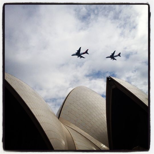 Over the iconic sails of the Opera House. Qantas