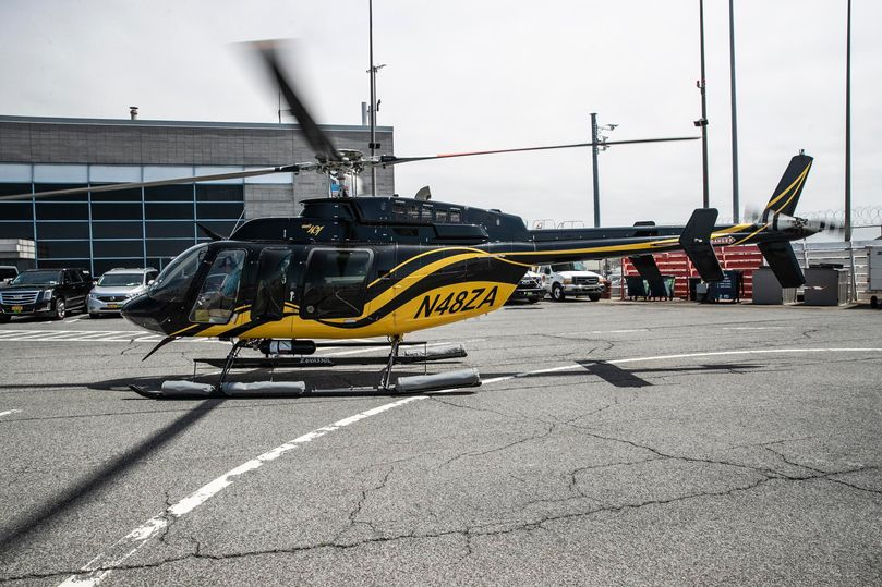 A Blade helicopter lands at John F. Kennedy Airport, where a complimentary black SUV whisks passengers to their airline's terminal.