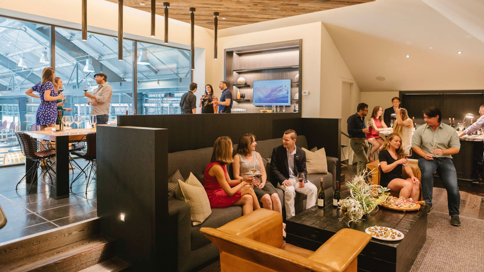 Inside the tasting room at Kosta Browne, a large glass window looks out over the barrel room.