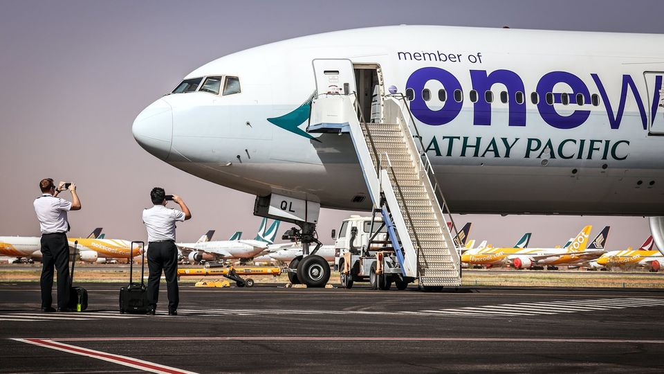 Cathay Pacific Pilots photograph their aircraft, which is headed for the APAS facility, after landing at Alice Springs Airport.. David Gray/Bloomberg