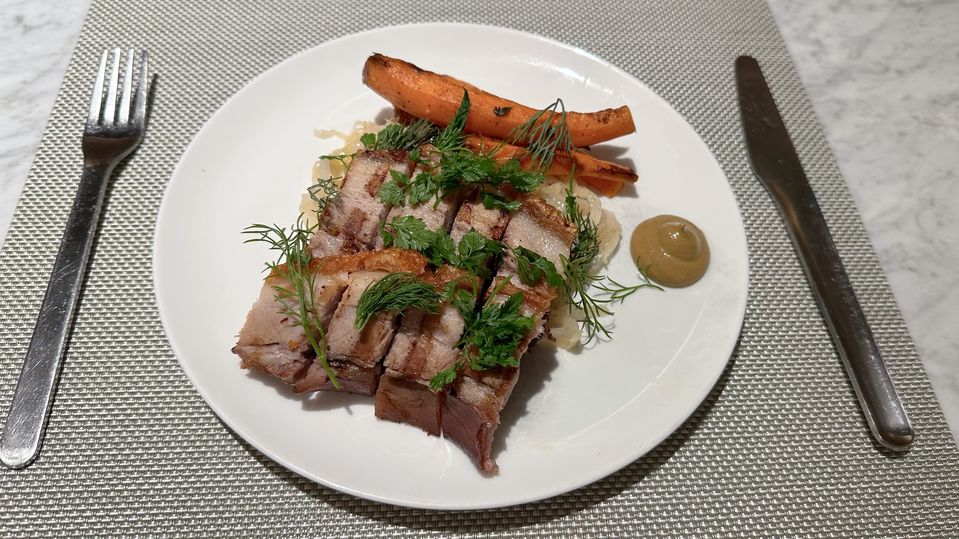 Crispy pork belly with braised cabbage, baby carrots and mustard.