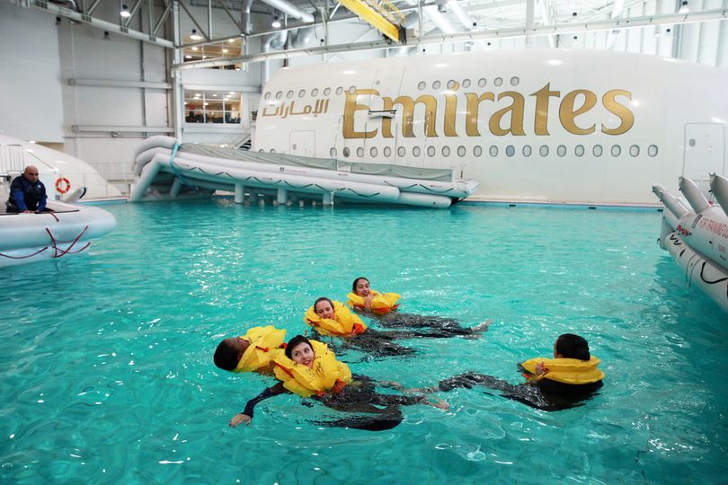 (The pre-inflated slides attach to the life-sized A380 mockup during training.)